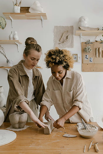 Vrouwen die met klei werken, aardewerk workshop, klei, creativiteit, vakmanschap, twee vrouwen, klei kunst, keramische kunst, handgemaakt aardewerk, artistiek proces, studio -setting