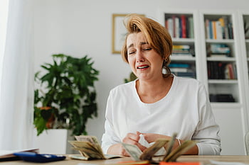 žena počítá peníze, Plačící žena, Finanční napětí, zoufalá žena, Bolestný výraz, Počítání hotovosti, stůl scénu, emocionální stres, Správa peněz, finanční problémy, Nastavení domácí kanceláře