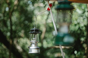 gammaldags lyktor, vintage lantern, läger i skogen, solbelyst skog, nostalgi, lugn, utomhus lyktor, hängande lykta, skogsband, vintage campingutrustning, utomhusbelysning