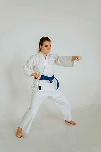 giovane donna, kimono bianco, karate kata, cintura blu, arti marziali, pratica in studio, GI bianco, tecnica di karate, artista marziale femminile, Allenamento al chiuso, posa di karate