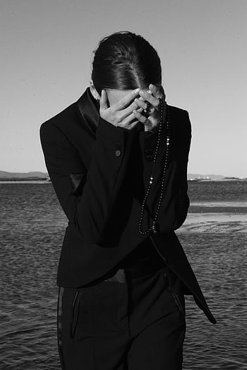 fotografie ve stupních šedi, osoba pokrývající obličej, černobílý portrét, elegantní móda, Ruce drží korálky, Monochromatický obrázek, Stylový outfit, venkovní nastavení, umělecká fotografie, módní fotografie, kontemplativní pozice