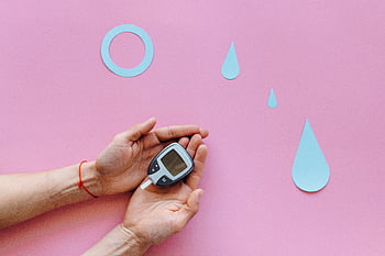 glukometr, diabetes, elektronické zařízení, růžový povrch, modré symboly, ruce hospodářství, krevní cukr, Monitorování zdraví, zdravotnické zařízení, Povědomí o diabetu, zdravotní péče