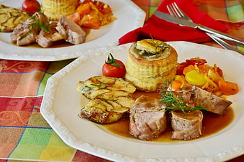 filetto di maiale, verdure, sfoglia, guarnizione di pomodoro, pranzo gourmet, piatto elegante, pasto placcato, cucina raffinata, piatto da cena, presentazione culinaria, verdure colorate