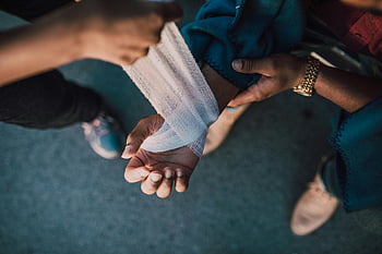 bendare, polso ferito, scena all'aperto, Mani che si applicano, colpo di dettaglio, cure mediche, primo soccorso, assistenza all'aperto, Lesioni del polso, applicazione del bendaggio, Cure mediche all'aperto