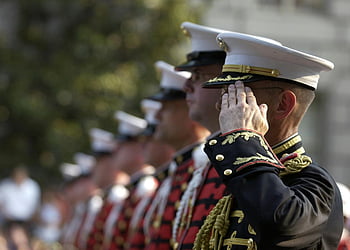 men in uniform, military parade, black and yellow suits, standing in line, daytime event, ceremonial uniform, saluting soldiers, formal military attire, outdoor ceremony, uniformed men, parade formation