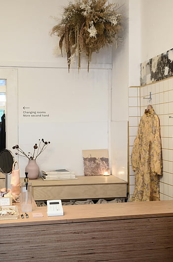 blatul în stil clasic, magazin de haine, decor rustic, expunere de haine elegante, interior confortabil de tip boutique, blat de lemn, flori uscate agățate, peretele din fațadă, semn pentru vestiare, haine la mâna a doua, Estetică vintage