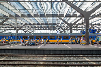 Rotterdam Central Station, people waiting, train station, boarding trains, day time, train tracks, public transportation, commuters, station platform, modern architecture, Netherlands