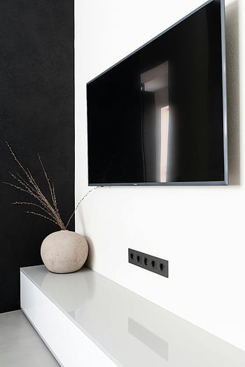 현대 TV 세트, 벽걸이 TV, 매끄러운 검은 TV, 최소한의 거실, 세련된 가정 장식, 우아한 꽃병, 현대적인 장식, 검정색과 흰색, 현대적인 디자인, 거실 장식, 벽 마운트 텔레비전