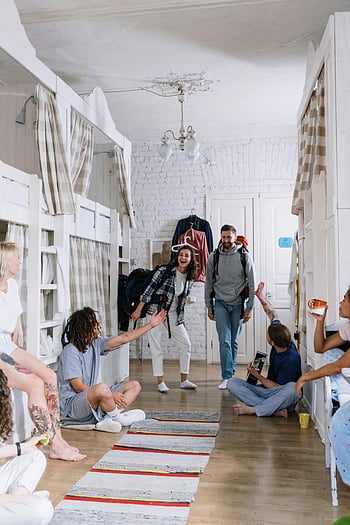 Des amis se sont réunis, diverses routards, Socialisation joyeuse, dortoir confortable, atmosphère animée, interaction de groupe, Rencontre des routards, rassemblement de dortoirs, Amis dans le dortoir, atmosphère sociale, Groupe diversifié