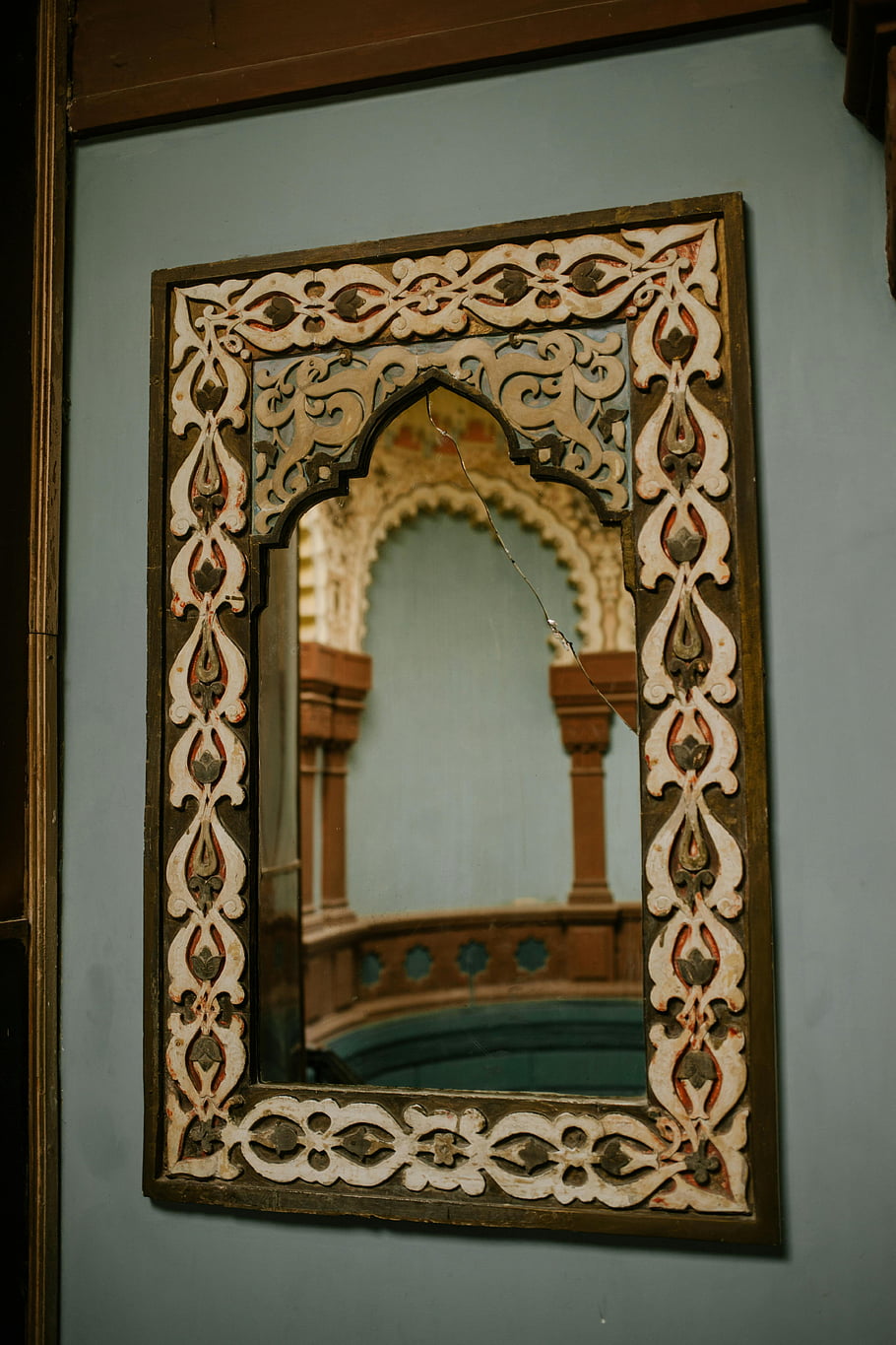 ornamental mirror, oriental building, antique mirror, ornate frame, historic architecture, indoor reflection, detailed mirror, decorative mirror, wall-mounted mirror, cultural decor, architectural features