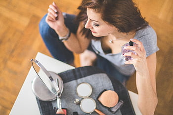 junge Frau, Parfüm auftragen, Make -up -Essentials, Schönheitsroutine, Körperpflege, Parfümflasche, Schminkspiegel, Hautpflege, Schönheitsprodukte, Schönheitstipps, Schönheitshacks