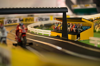 model motocykla, miniaturowy tor, trybuna dla widzów, fotografia szczegółowa, czerwona zabawka sportowy rower, Szczegółowa miniatura, scena wyścigowa, wyścigi zabawek, wyścigi modeli, tor zabawkowy, widzowie zabawek