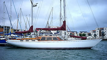 white and brown sail boat, maroon sails, picturesque harbor, sleek yacht, docked boats, body of water, marina scene, harbor view, sailing vessel, yacht maroon sails, waterfront setting