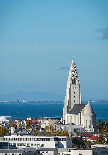 Hallgrimskirkja, modern style church, waterside, Reykjavik, ocean backdrop, mountains, Iceland, architecture, landmark, cityscape, skyline