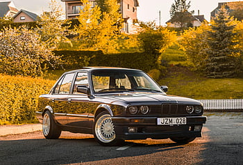 BMW E30, vintage car, black car, suburban street, sunny day, classic sedan, retro charm, parked car, E30 BMW, vintage BMW, classic car