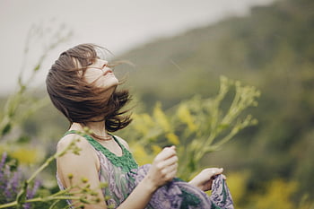 woman in dress, wind rustling hair, serene moment, lush green landscape, outdoor portrait, natural beauty, peaceful scene, wind blowing, green dress, nature photography, woman enjoying wind