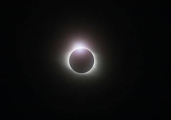 solar eclipse, glowing corona, dark sky, radiant glow, captivating image, celestial event, eclipse photography, night sky, astronomical phenomenon, solar corona, eclipse view