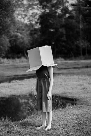 woman with box, faceless woman, cardboard box, black and white, outdoor nature, pond, artistic photography, surreal art, hidden head, monochrome image, natural setting