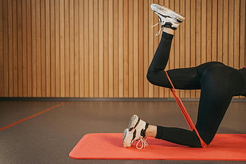 black leggings, leg exercise, resistance band, activewear, indoor workout, yoga mat, leg workout, fitness, exercise, woman working out, indoor fitness