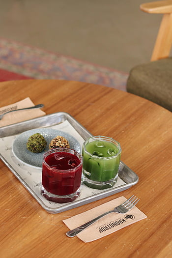 Here are the most relevant photo keywords for SEO based on the provided caption, description, and the photo:

1. **Vibrant Drinks**
2. **Juices on a Table**
3. **Health Snacks**
4. **Café Table**
5. **Red and Green Juices**
6. **Refreshing Break**
7. **Juice and Snacks**
8. **Table Drinks**
9. **Healthy Refreshments**