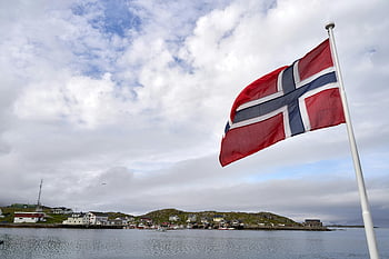 Norway flag, coastal village, serene waters, cloudy day, calm waters, Norwegian flag, flag on pole, body of water, seaside village, coastal scenery, flag waving