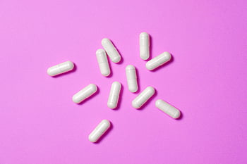tobolky bílé medicíny, Vibrující růžové pozadí, Moderní farmaceutický design, detailní fotografie, rozptýlené tobolky, bílé pilulky, Růžové pozadí, Farmaceutické výrobky, lékařské snímky, Design kapsle, Vizuální efekty léků
