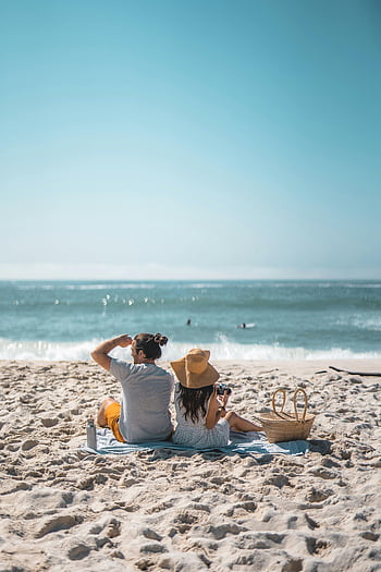 beach picnic, couple relaxing, summer picnic, ocean view, beach couple, sandy beach, beach blanket, picnic basket, beach vacation, beach scene, beach couple relaxing