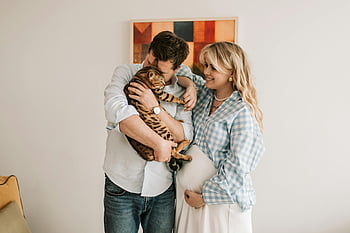 pregnant woman, man, pet cat, Bengal cat, expecting couple, affection, indoors, joyful moment, pregnant belly, couple with cat, indoor affection