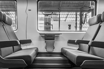 grayscale photograph, vehicle seats, modern train interior, empty leather seats, large windows, black and white image, train seats, interior design, public transportation, travel photography, train cabin