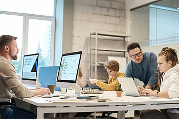 people near computers, modern office setting, team of professionals, project ideas, communication, teamwork, office environment, collaborative work, professional discussion, workplace interaction, computer work