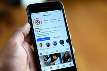 smartphone, close-up, Instagram profile, hand holding phone, social media, mobile device, app screen, digital display, user interface, profile page, followers