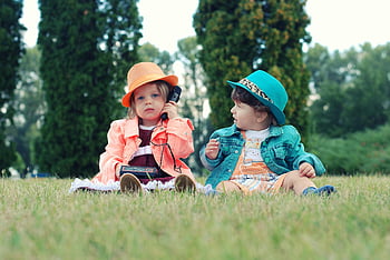 batolata, Barevné oblečení, Walkie Talkies, slunečný park, travnaté hřiště, venkovní hry, děti si hrají, klobouky, Nastavení přírody, dvě děti, hravá scéna