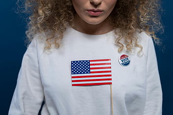 donna, bandiera americana, capelli ricci, Pin di voto, sfondo blu, camicia bianca, politico, patriottico, elezione, democrazia, attivismo