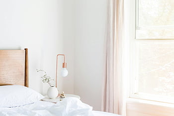 white table lamp, vase, side nightstand, bright minimalist bedroom, modern furniture, natural lighting, bedroom decor, white bedding, wooden headboard, window, curtains