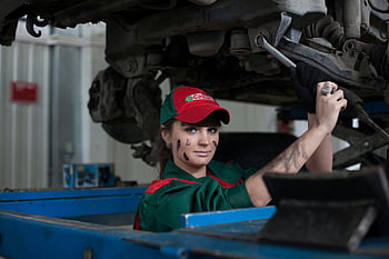 ženský mechanik, údržby vozidel, autoopravna, Šedý ocelový klíč, dovednost a koncentrace, oprava auta, Mechanické nástroje, automobilový průmysl, Profesionální mechanik, autoservis, údržba vozidla